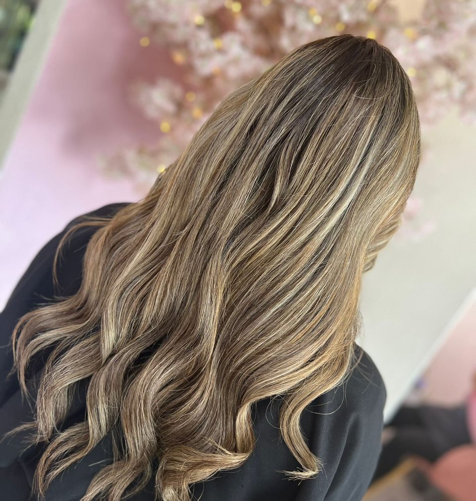 Clienta con balayage largo en Stilo Salón, Roma Norte, con el salón al fondo